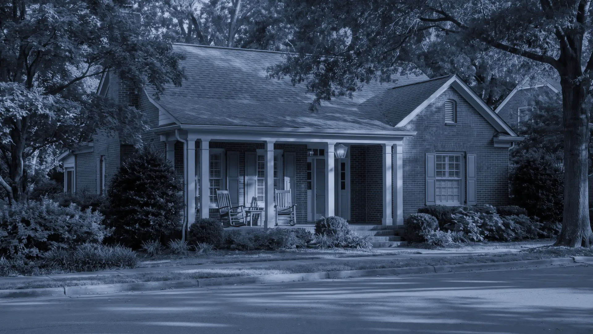 A Charlotte home at dusk, warm interior light glowing through large, flawless glass.